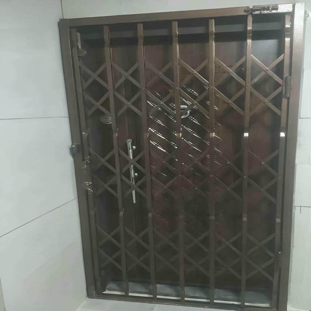 حفاظ ضربدری آکاردئونی جمع شده کنار در قدیمی